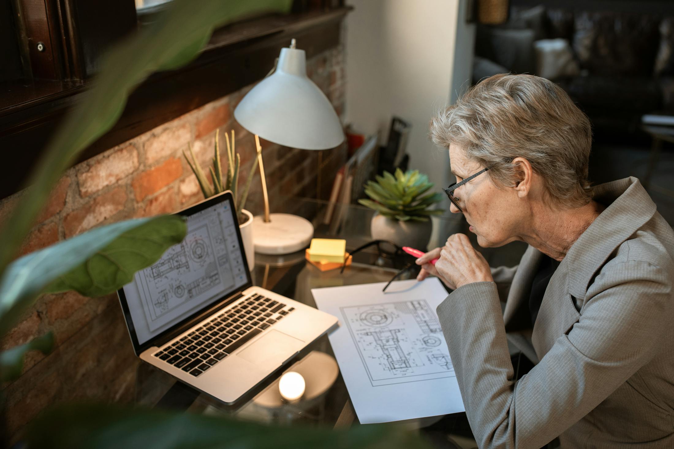 Senior boomer woman using laptop at home to explore side hustles and make extra money after 60.